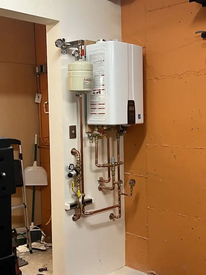 Plumbing technician inspecting water heater connections in Morris